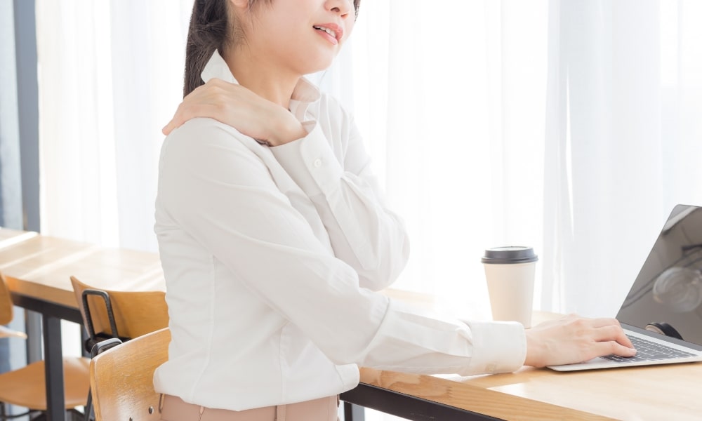 肩コリで痛そうな女性