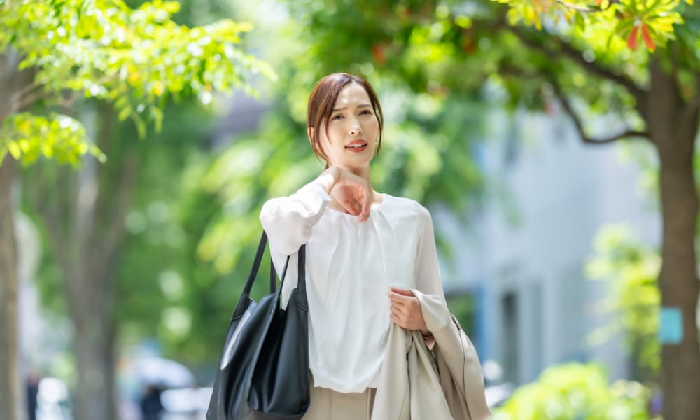ジメジメした暑さで辛そうな女性
